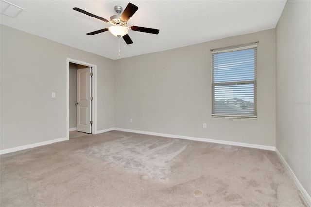 spare room featuring light colored carpet and ceiling fan