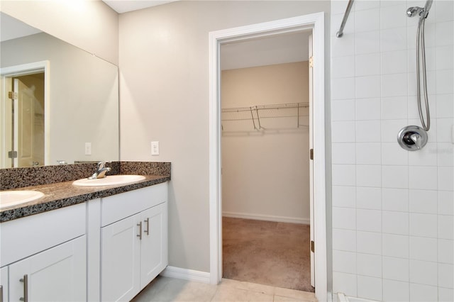 bathroom featuring vanity, tile patterned flooring, and tiled shower