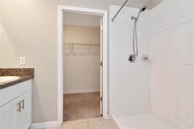 bathroom with vanity, tiled shower, and tile patterned floors