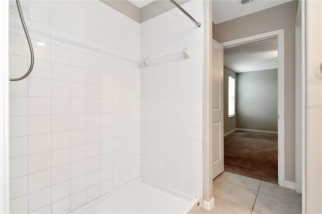 bathroom featuring tile patterned flooring and a tile shower