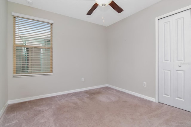 unfurnished bedroom with light colored carpet, ceiling fan, and a closet