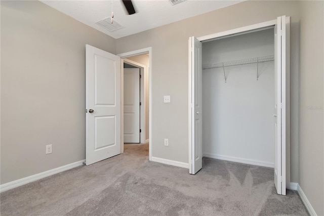 unfurnished bedroom featuring light colored carpet, ceiling fan, and a closet