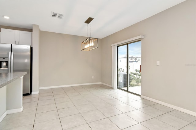 unfurnished dining area with baseboards, visible vents, and light tile patterned flooring