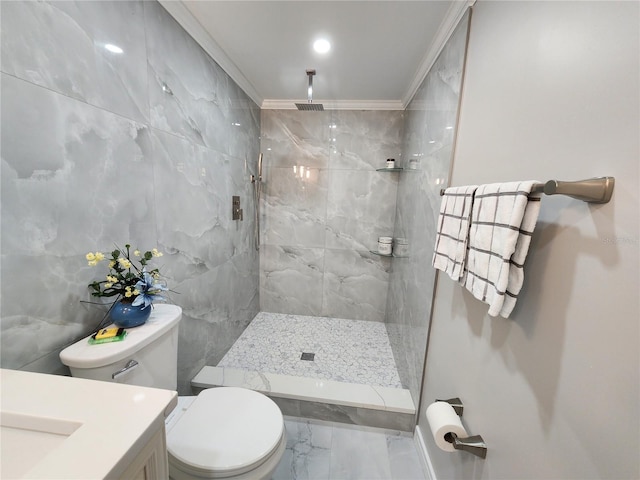 bathroom with a tile shower, tile walls, ornamental molding, vanity, and toilet