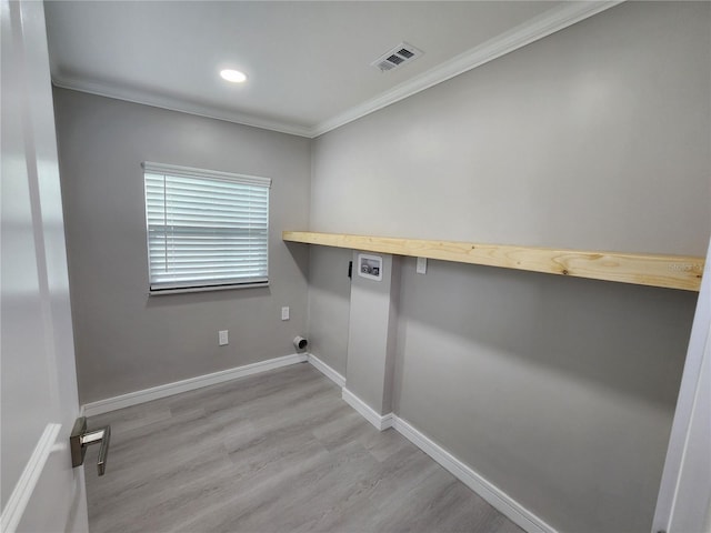 clothes washing area with ornamental molding, washer hookup, and light wood-type flooring