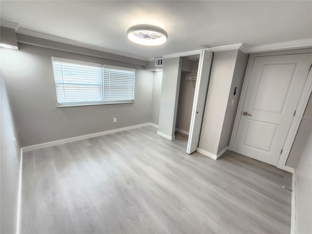 unfurnished bedroom featuring ornamental molding and light hardwood / wood-style floors