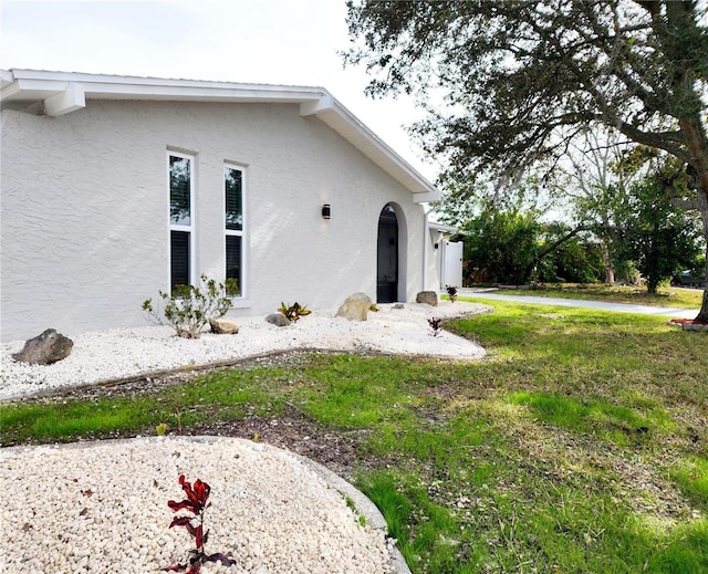 exterior space featuring a lawn and stucco siding