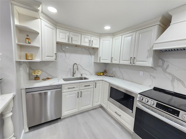 kitchen featuring sink, decorative backsplash, custom exhaust hood, light stone counters, and stainless steel appliances