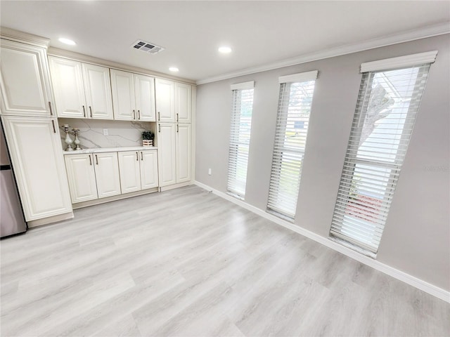 bar with backsplash, ornamental molding, and light wood-type flooring