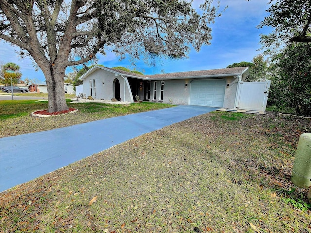 ranch-style house featuring driveway, a front lawn, and a garage