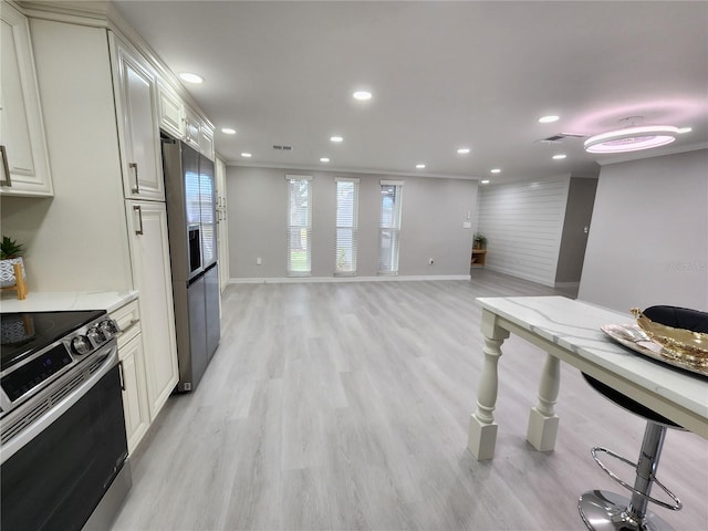 kitchen featuring light stone counters, light wood-type flooring, appliances with stainless steel finishes, and recessed lighting