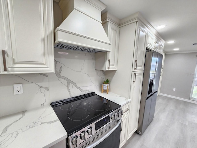 kitchen featuring premium range hood, stainless steel appliances, decorative backsplash, white cabinets, and light wood-type flooring