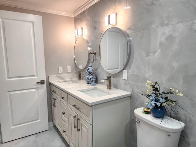 bathroom featuring double vanity, marble finish floor, crown molding, and a sink