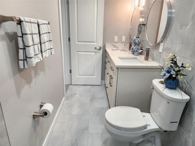 bathroom featuring toilet, marble finish floor, and vanity