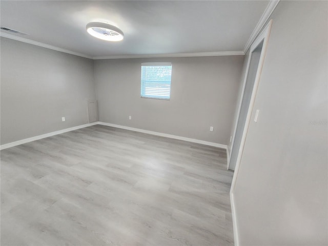 unfurnished room featuring visible vents, light wood-type flooring, baseboards, and ornamental molding