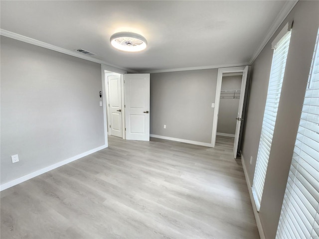 unfurnished bedroom featuring light wood-type flooring, visible vents, baseboards, and ornamental molding