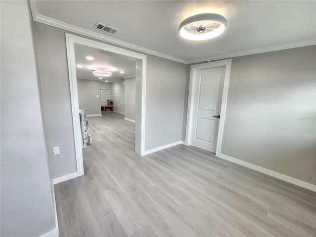 unfurnished room with visible vents, crown molding, baseboards, and wood finished floors