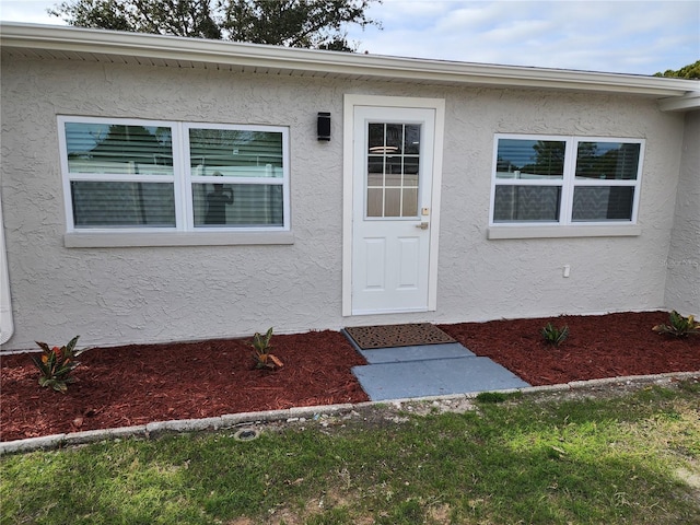 property entrance with stucco siding