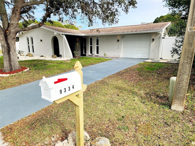 single story home with stucco siding, a front lawn, driveway, fence, and a garage