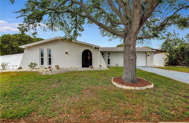 9334 Ledgestone Ln, Port Richey, FL 34668 - ranch-style house with an attached garage, concrete driveway, a front yard, and fence