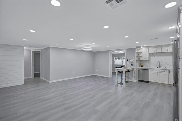 9334 Ledgestone Ln, Port Richey, FL 34668 - unfurnished living room featuring baseboards, ornamental molding, recessed lighting, visible vents, and light wood finished floors