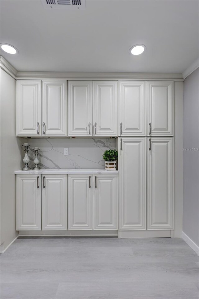 9334 Ledgestone Ln, Port Richey, FL 34668 - interior space featuring white cabinets, tasteful backsplash, light wood-style floors, and baseboards