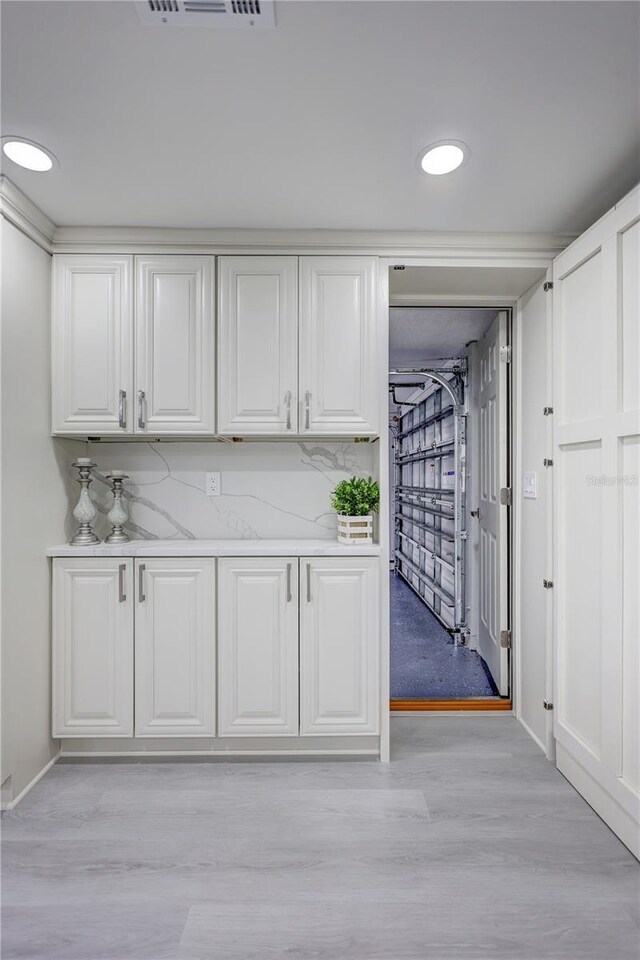 9334 Ledgestone Ln, Port Richey, FL 34668 - kitchen with light wood-type flooring, white cabinetry, and recessed lighting