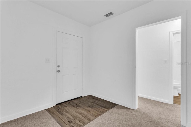 foyer entrance featuring carpet flooring