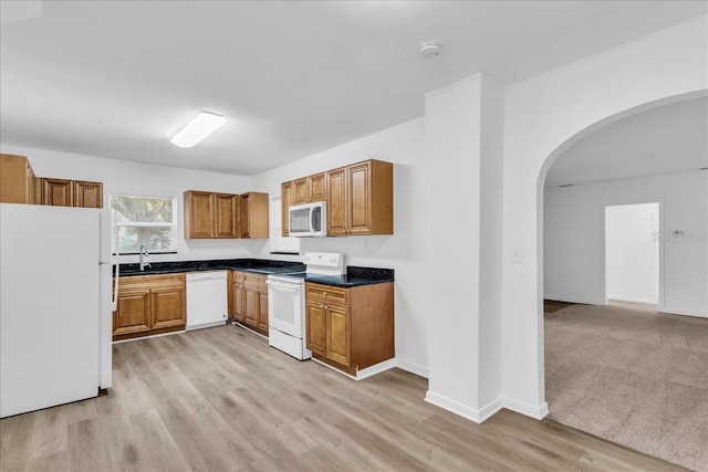 kitchen featuring sink, light hardwood / wood-style flooring, and white appliances