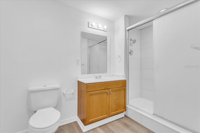 bathroom with toilet, wood-type flooring, walk in shower, and vanity