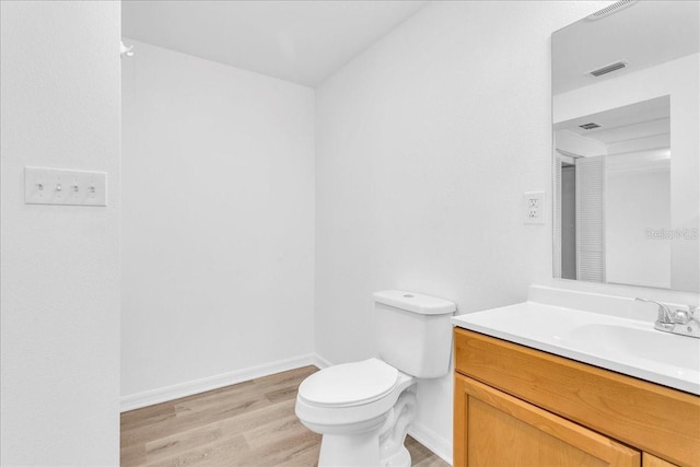 bathroom featuring toilet, wood-type flooring, and vanity