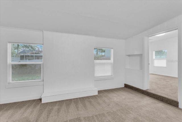 empty room featuring carpet floors and built in shelves