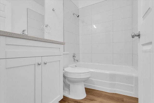 bathroom featuring toilet, tiled shower / bath combo, and wood-type flooring