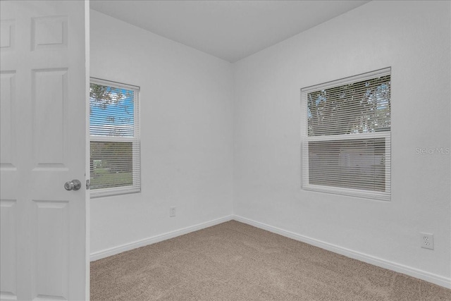 spare room featuring light colored carpet