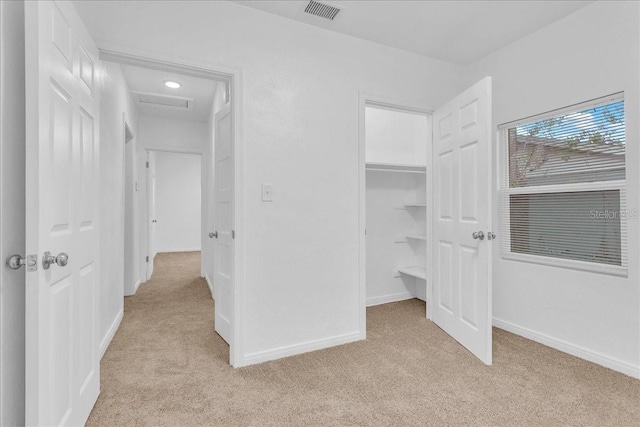 unfurnished bedroom featuring light carpet and a closet