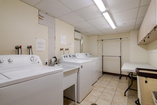 laundry room with separate washer and dryer, cabinets, and light tile patterned floors