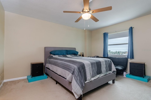 bedroom with baseboards, a ceiling fan, and light colored carpet