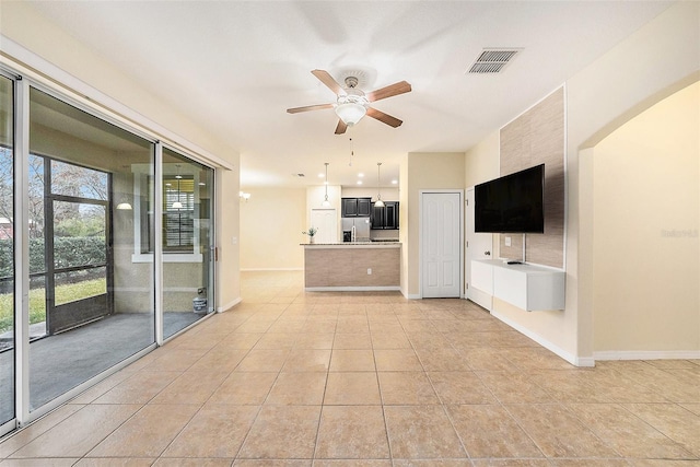 unfurnished living room featuring light tile patterned floors and ceiling fan