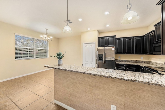 kitchen featuring an inviting chandelier, light tile patterned floors, appliances with stainless steel finishes, pendant lighting, and light stone countertops