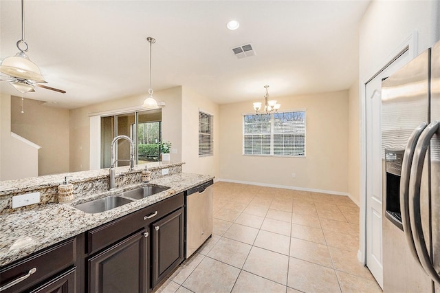 kitchen featuring light stone countertops, appliances with stainless steel finishes, sink, and pendant lighting