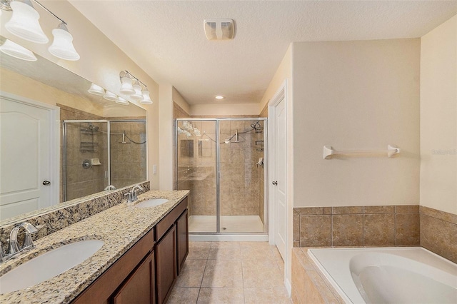 bathroom featuring tile patterned floors, separate shower and tub, vanity, and a textured ceiling