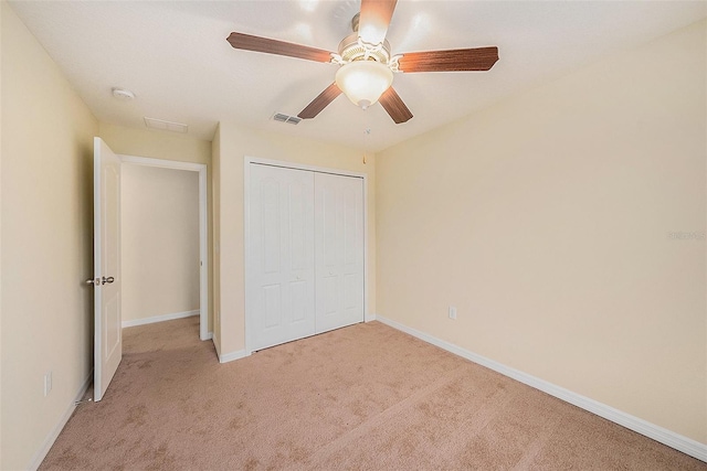 unfurnished bedroom featuring light carpet, ceiling fan, and a closet