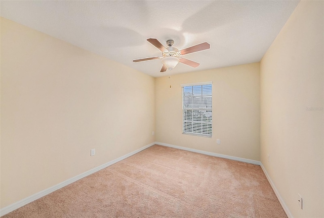 empty room featuring ceiling fan and light colored carpet