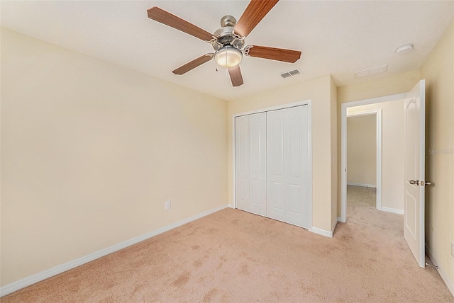 unfurnished bedroom featuring ceiling fan, light carpet, and a closet