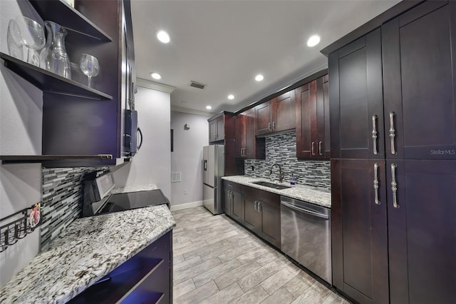 kitchen featuring sink, light hardwood / wood-style flooring, appliances with stainless steel finishes, ornamental molding, and light stone counters