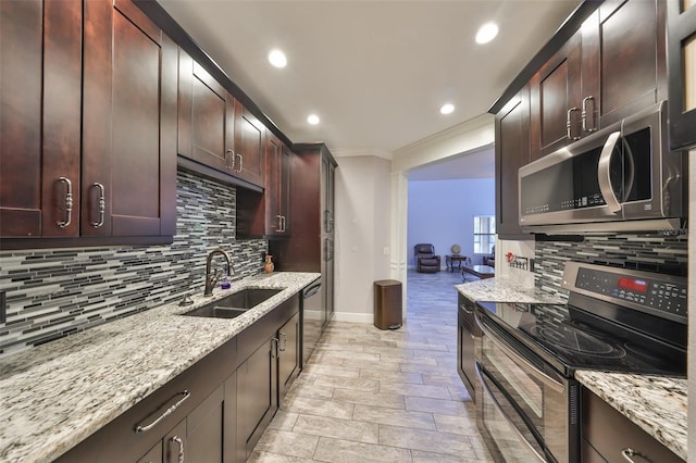 kitchen with light stone countertops, sink, backsplash, and appliances with stainless steel finishes