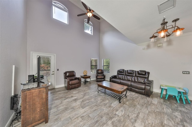 living room featuring ceiling fan, a towering ceiling, and hardwood / wood-style flooring