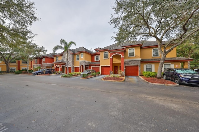 2160 Chianti Pl Unit 11-0117, Palm Harbor, FL 34683 - view of front of house featuring a residential view, an attached garage, stone siding, and stucco siding
