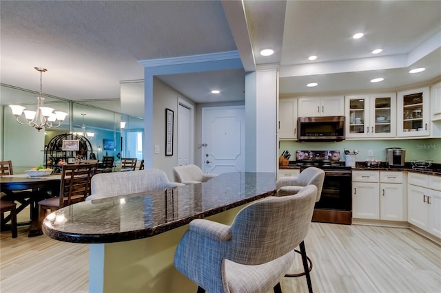 dining area with ornamental molding, a chandelier, and light wood-type flooring