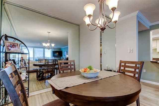 dining space with light hardwood / wood-style floors, crown molding, and a chandelier